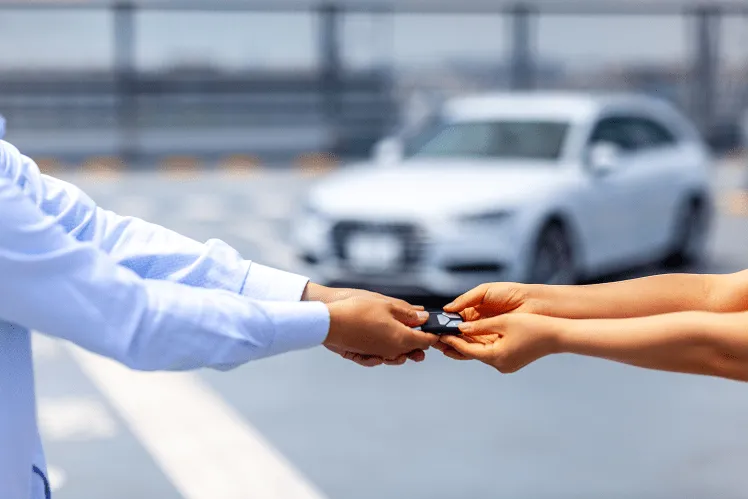 A woman renting a car at a Japanese car rental agency during her trip after completing the paperwork