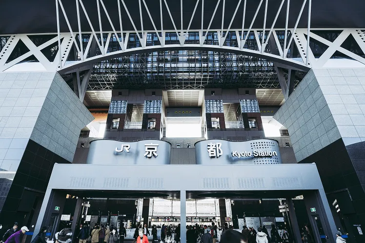 The busy and magnificent Kyoto Station is filled with crowds of locals and tourists, its futuristic architecture bustling with energy and movement