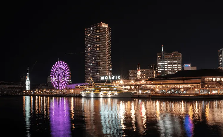 Kobe Harborland at night transforms into a dazzling waterfront wonderland, where Kobe Port Tower glows with vibrant red and white lights